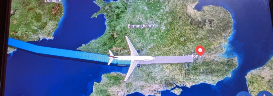 Flight tracker on plane that shows Destination of London and plane flying over England