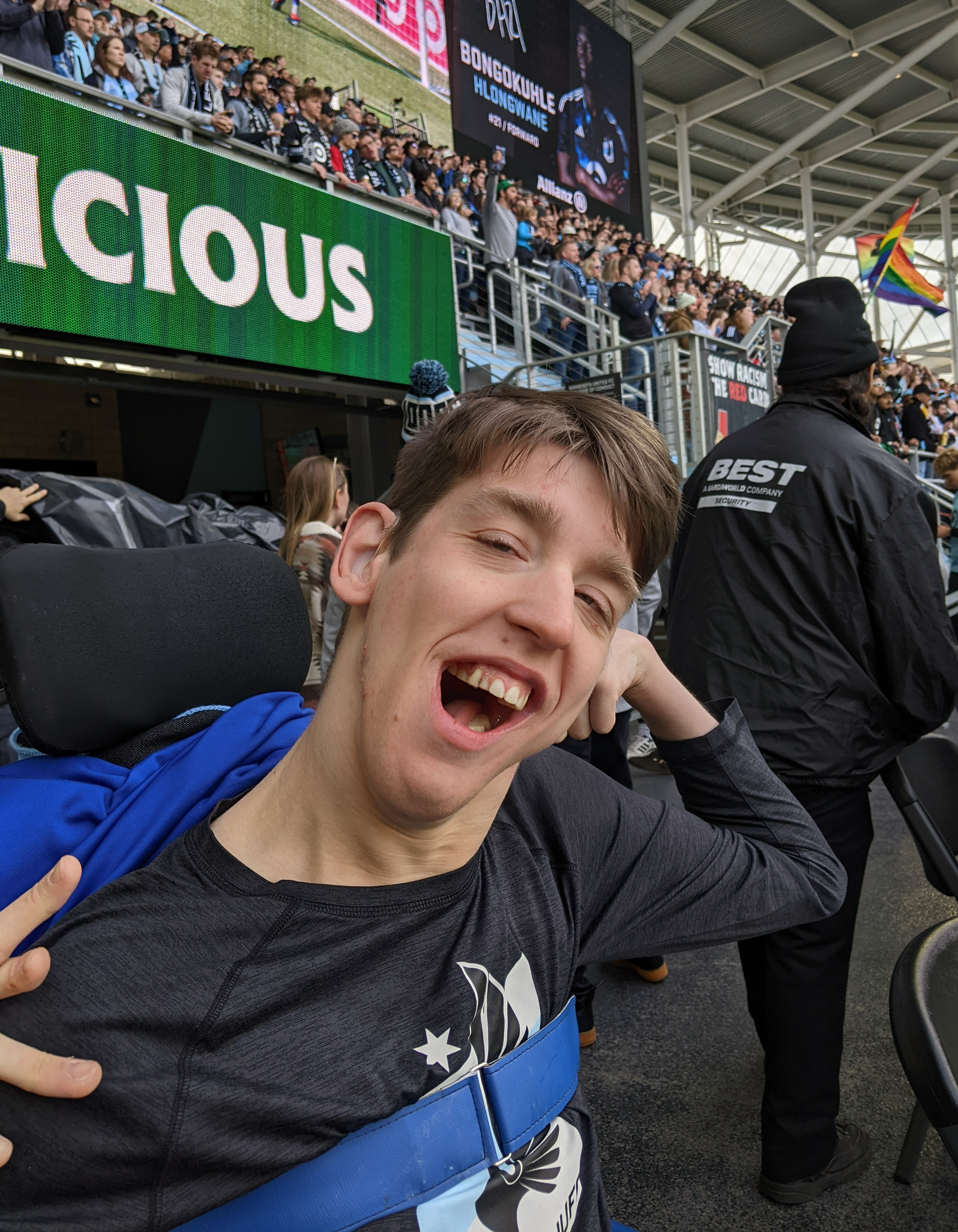 Justin in wheelchair wearing MN Wild shirt, stadium crowd behind